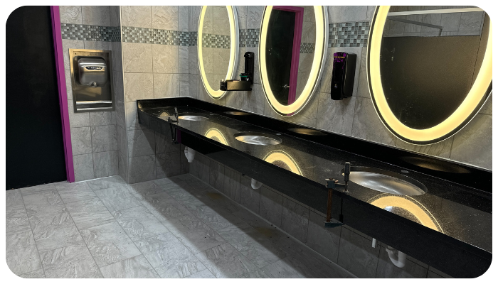 modern commercial bathroom interior with custom countertops and illuminated mirrors